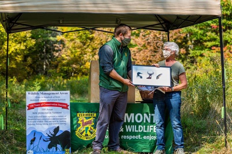 Photo of ceremony with a map and award